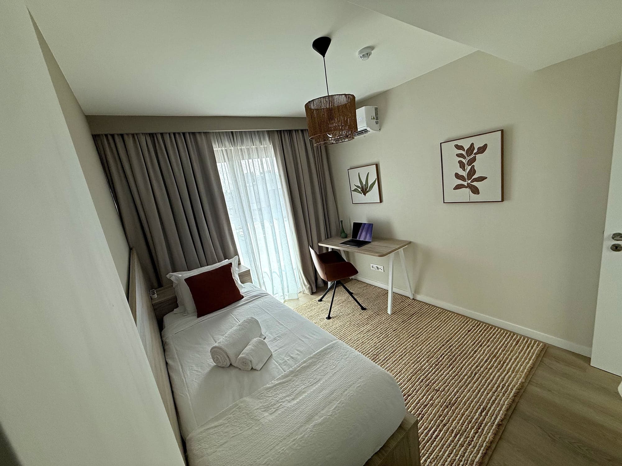 The third bedroom at Blue Cove made up as a single, with the desk and jute rug