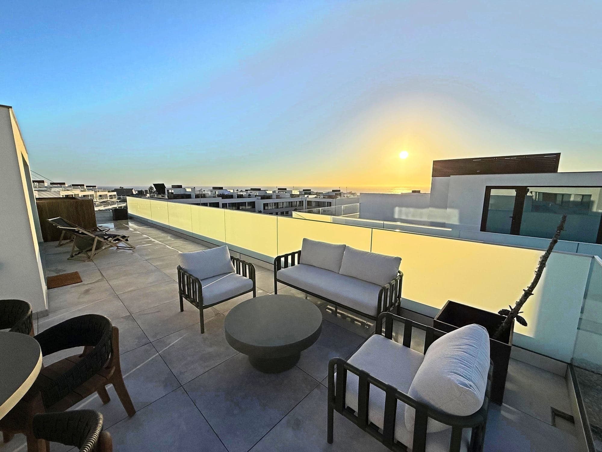 Outdoor lounge seating on the terrace at Blue Cove at sunset