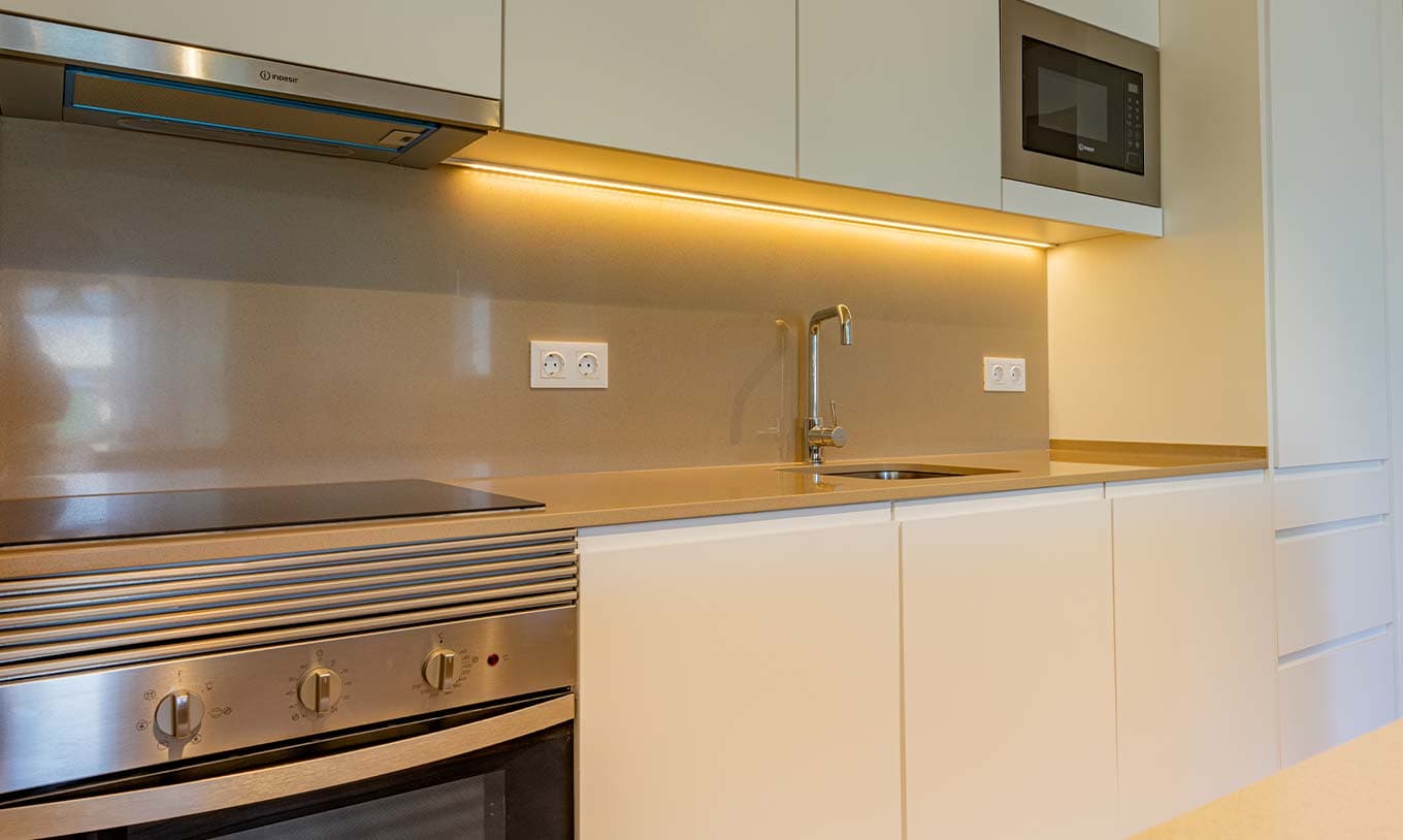 Fully equipped kitchen with warm cabinetry, stone counters and under-cabinet lighting