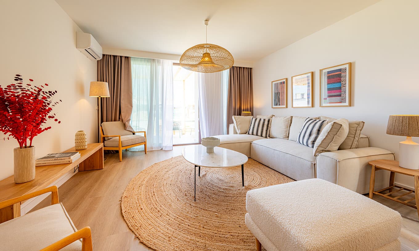 Sunlit living room with a linen sofa, jute rug, rattan pendant and warm oak floors