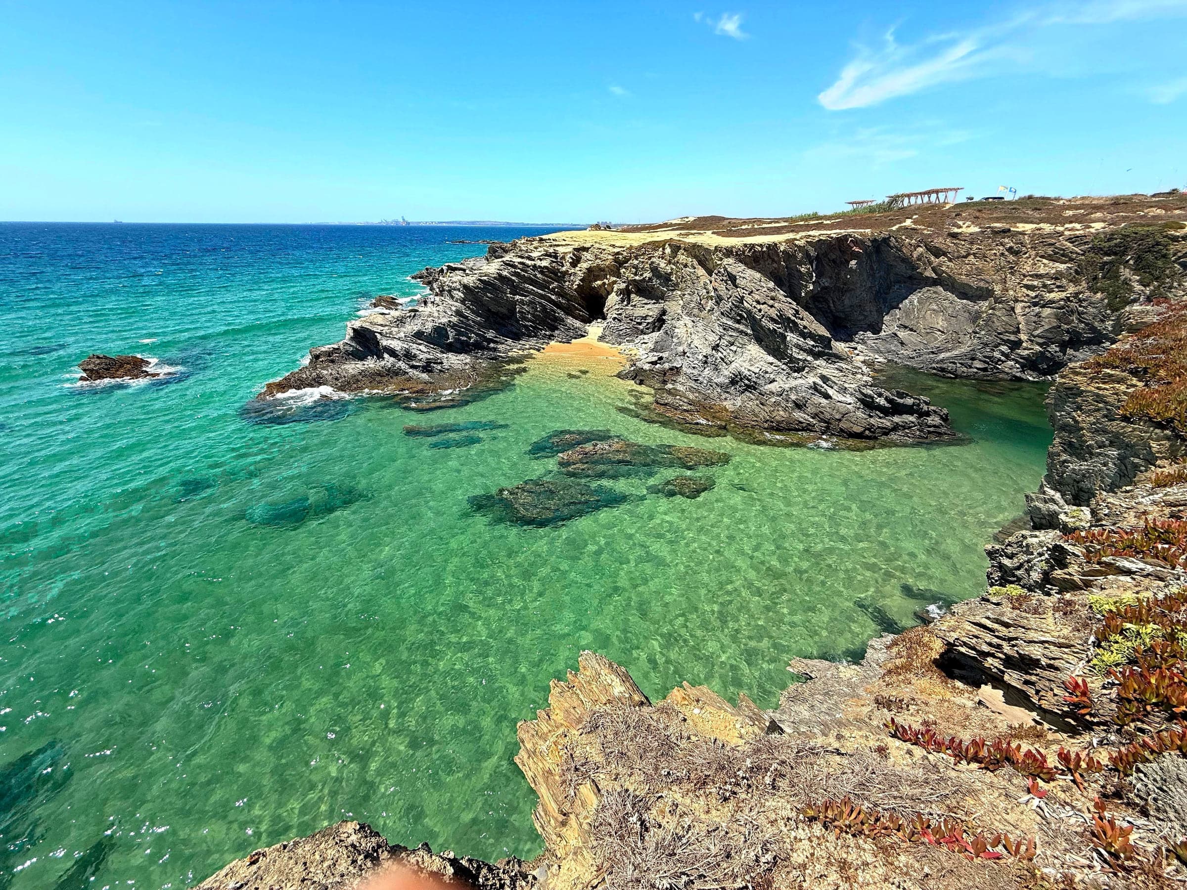 The Rota Vicentina clifftop path above an emerald cove on the Atlantic coast at Porto Covo