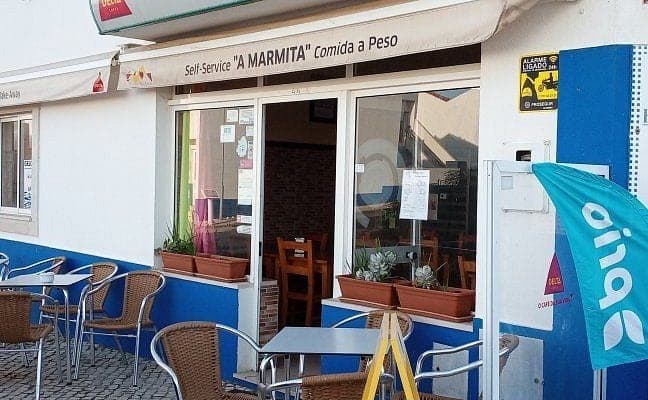 A Marmita's blue and white shopfront, pavement tables outside beneath the comida a peso sign