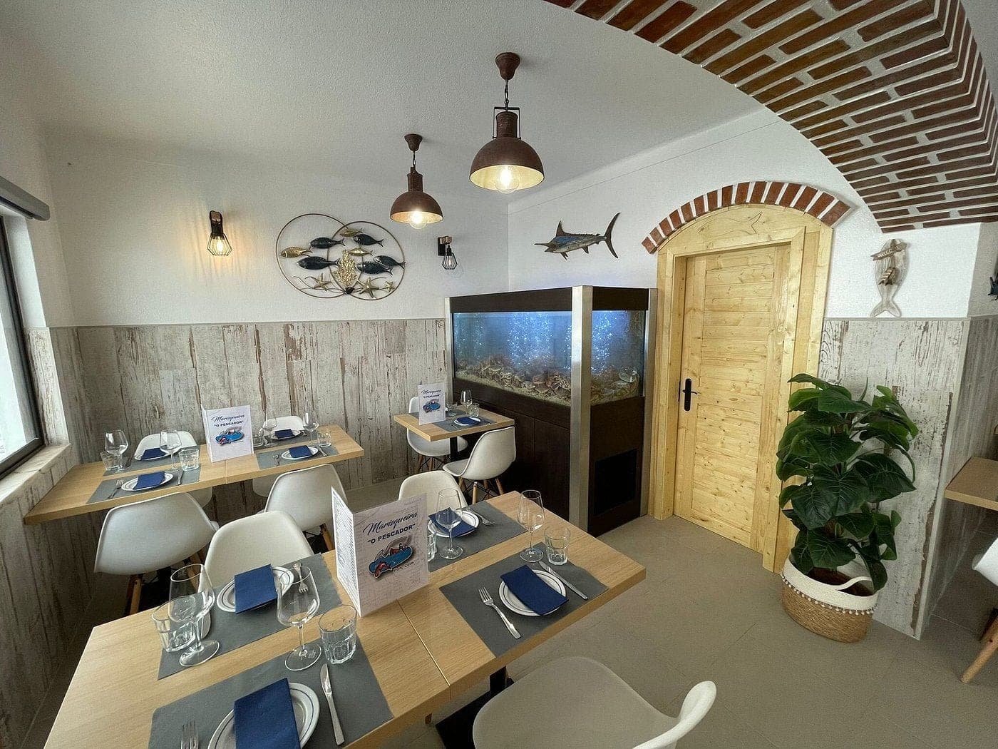 The dining room at O Pescador, brick vaulting overhead and an aquarium set into the wall