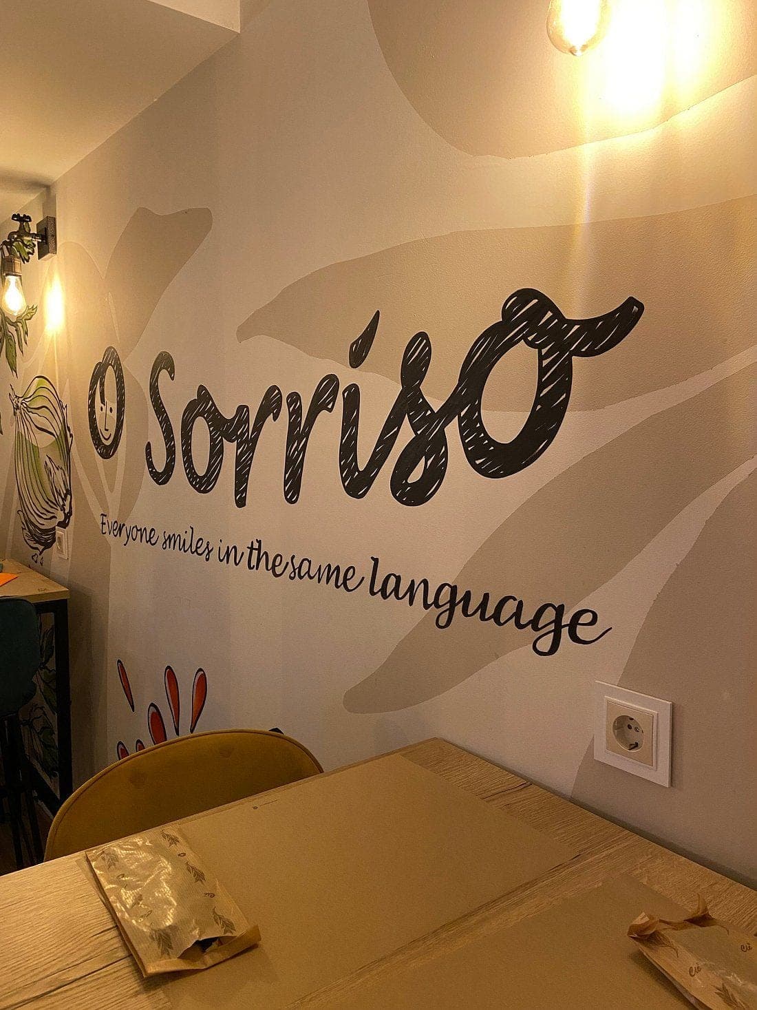 O Sorriso's name painted across the dining-room wall above a laid table