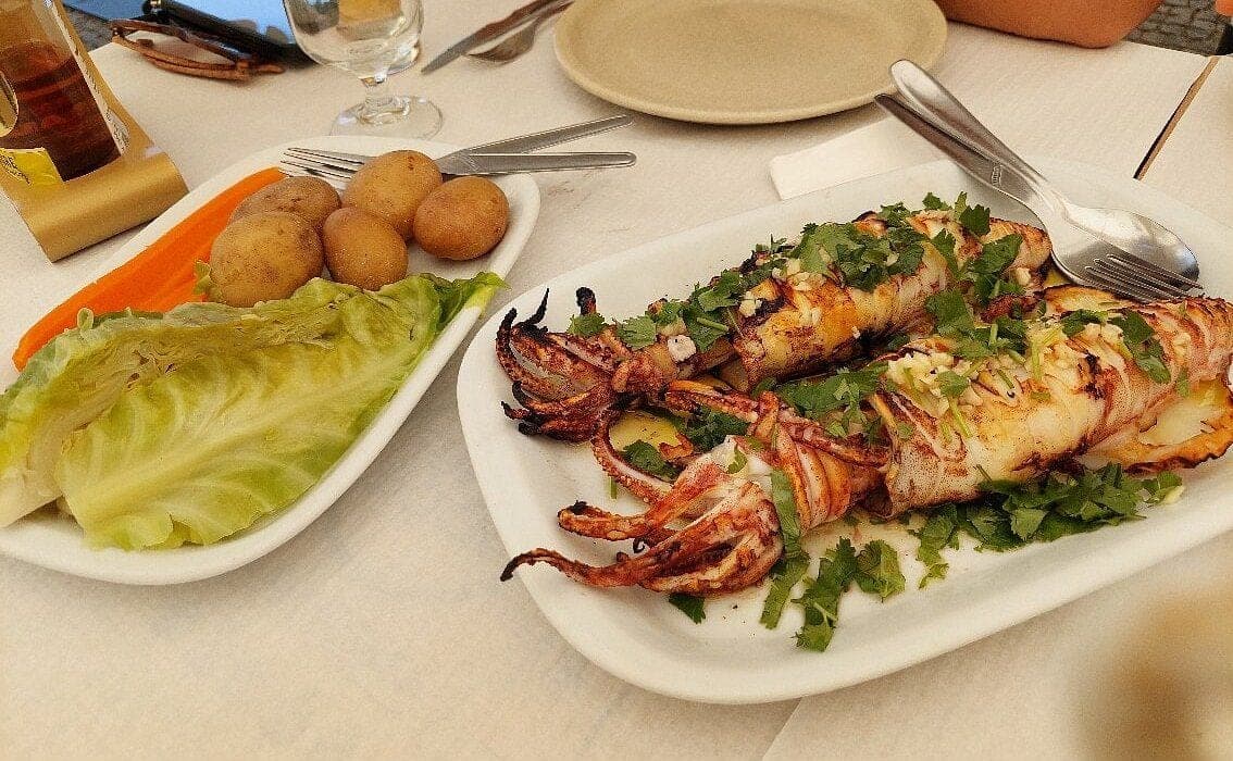 Grilled squid with new potatoes and salad, on the table at Ti Joaquim