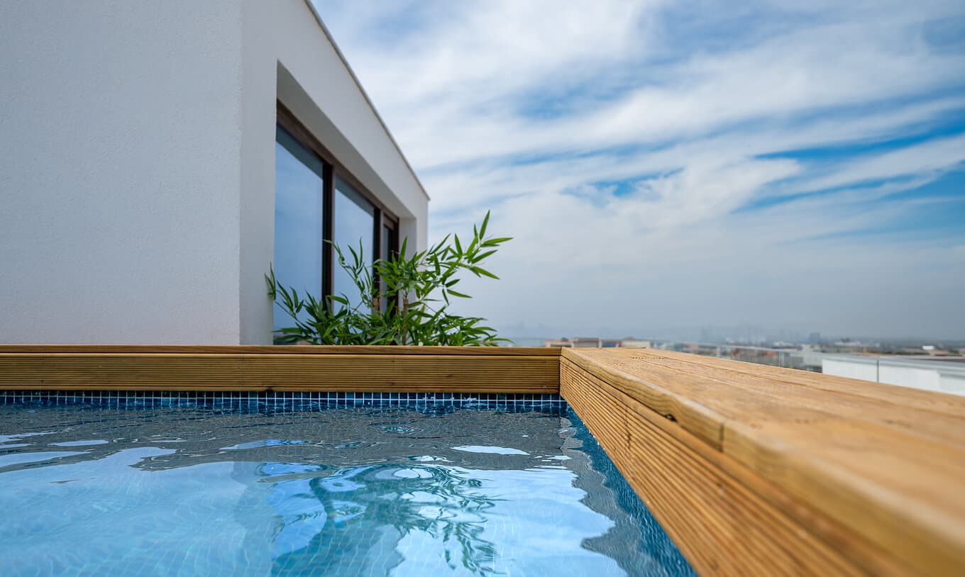The warm-wood pool deck at Blue Cove overlooking the Alentejo coast